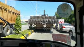 Truck driver with a very wide load squeezes through tiny gap in traffic