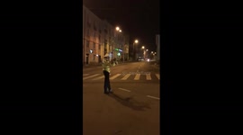 A policeman conducts traffic with a bunch of flowers in hand