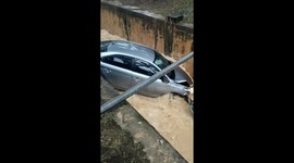Car washed away after skidding off the road and into a STORM DRAIN in heavy rains