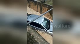 Car washed away after skidding into a storm drain flooded by Malaysian monsoon