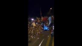 Locals frantically collect thousands of bottles of beer spilled from overturned truck