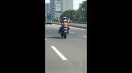 Toddler riding pillion on back of motorcycle with father