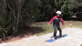 Australian science teacher gives daughter her first FlowRider experience using snowboard and shade cloth