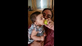 Six-month-old baby tries to eat an apple