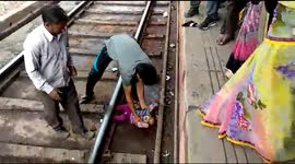 Moment miracle baby emerges unscathed after falling onto tracks and under moving train