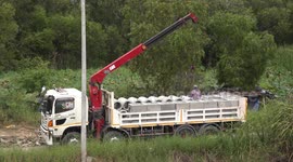 Concrete pipes being unloaded from a truck.
