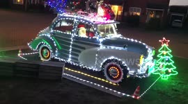 Vintage Morris Minor decorated with 10,000 Christmas lights at home in England