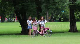 Pretty Thai ladies take a selfie in a beautiful summer park.