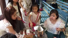 Lighting joss sticks at temple. Adults and children.