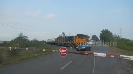 Reckless driver jumps level crossing barrier as train approaches