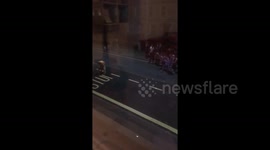 Crowds reaction to a painter finishing the last letter of a Bus Stop