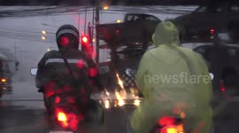 Stopped at traffic lights in heavy rain close to a port, at an industrial estate.