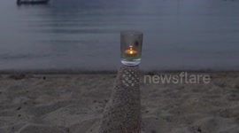 A lighted candle by the sea side