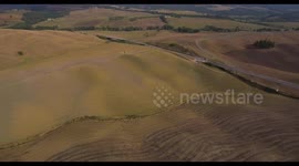 Aerial, the road crossing tuscan plowed fields in Italy