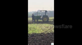 Moment stunt goes wrong when young farmer tries to leap on a moving tractor - but is dragged beneath the wheels.