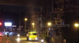 Thailand begins efforts to fight killer smog... with worker on truck spraying hose in the air