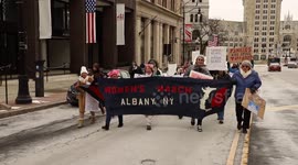 Albany, NY: Women’s March demonstrators carry banner in street