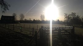 A pony and a horse enjoy a morning together after the frost