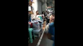 Old lady walks round market with pet dog and duck
