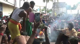 Devotees remove vada from boiling oil with bare hands in a temple festival in Southern India.