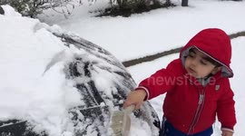 'My little champ!' Manchester toddler helps dad by brushing snow off car in freezing cold