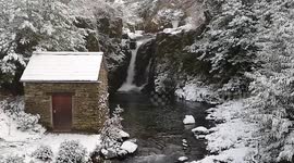 Waterfall looks beautiful in the snow in The Lake District, UK