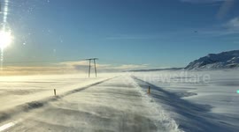 Strong winds blowing snow onto the road in south Iceland