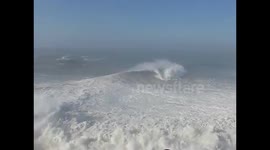 Crowds gather to watch huge waves off the coast of Portugal