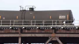 Crude oil tanker train passes over trestle on railway bridge over river in Paris Ontario Canada