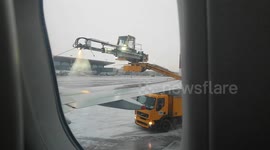 A plane is being covered by antifreeze liquid before taking off from cold and snowy weather in Russia