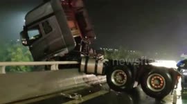 Firefighters use crane to save truck driver in trailer hanging off edge of a bridge