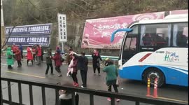 Stranded Chinese tourists get out of their bus and dance on icy motorway