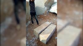 Skilled worker breaks stone pillar into equal pieces with a hammer in India