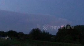 Distant pink lightning filled cloud