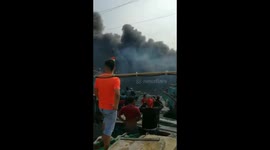 Tens of people watch at the port as fishermen boats burned out in Jakarta, Indonesia
