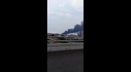 Jakarta residents watch the smoke billow kilometers away as a dozen of fishermen boats burned out