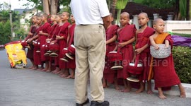 Young novice monks collect alms at a local food market, in early morning, three of the  young monk makes a big yawn.