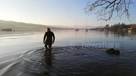 Boy braves icy waters for a sunset swim in Lake Windermere