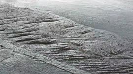 Water stream down sloping street in downpour