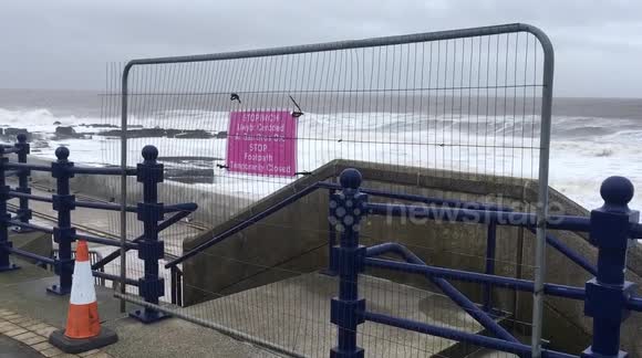 Wind Rattles Wind rattles barriers along closed coastal path in Wales during Storm ...