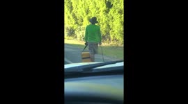 One-legged ice-cream seller struggles on roadside with his crutch
