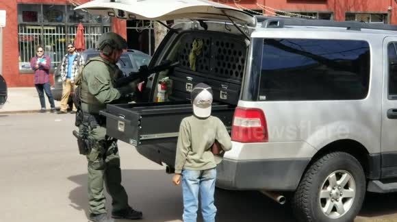 Young boy in awe as heavily armed police officer prepares for 'possible standoff' in Denver