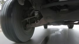 Closeup of tire on pavement driving on pothole covered bumpy roads after long cold Toronto winter