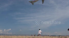 Tourists take selfies on beach next to airport (with royalty free music)