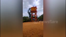 Bizarre Man climbs on over head tank for demanding political reform in India.