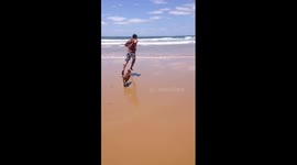 Dog trips owner on beach