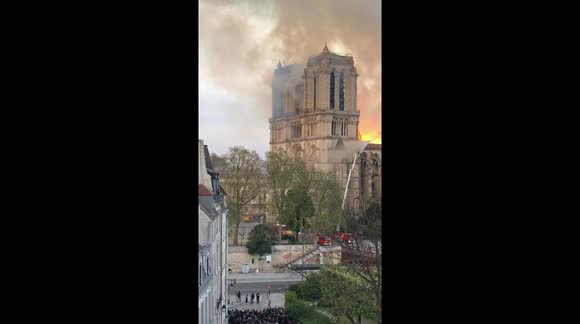 Crowds watch fire on the roof of the Notre Dame