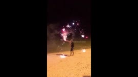 Little boy with fireworks having fun at the beach