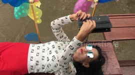 Thai girl relaxes on bench with wind toys. Online Business.