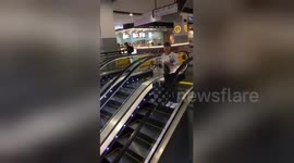 Packed for the holidays? Girl drops suitcase down escalator waving goodbye at airport